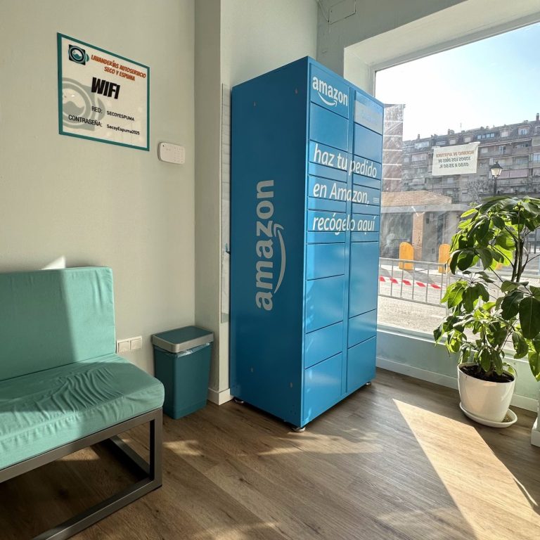 Amazon Locker Seco y Espuma Fuengirola Taquilla azul de Amazon en Lavandería Seco y Espuma Fuengriola, con una planta y muebles sencillos.